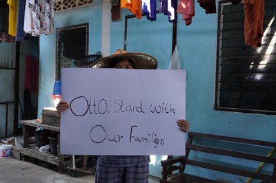Thai worker holding sign with Otto, stand with our families